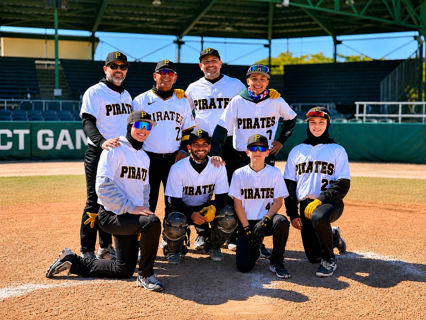 The Rios Family in their baseball uniforms around home plate